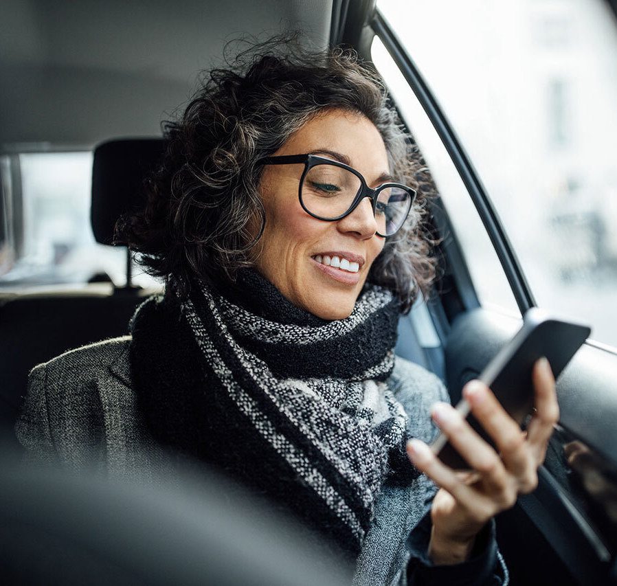 Femme en voiture, siège passager, devant son téléphone portable