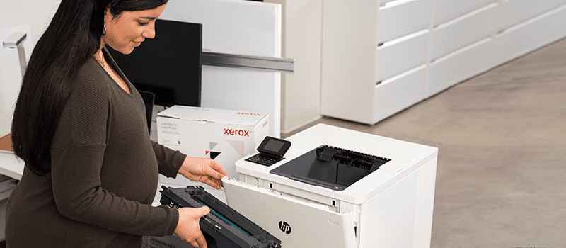 Femmes enceinte changeant des cartouches d'encre Xerox dans imprimante